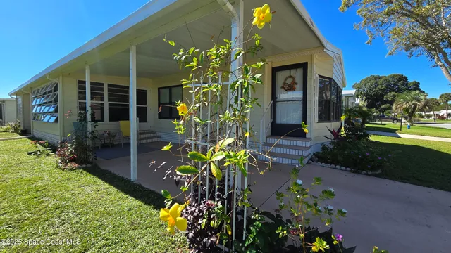 a vase of flowers sitting in front of a house