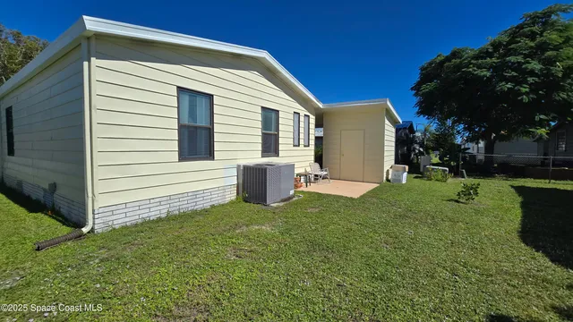 a view of a house with backyard and a tree