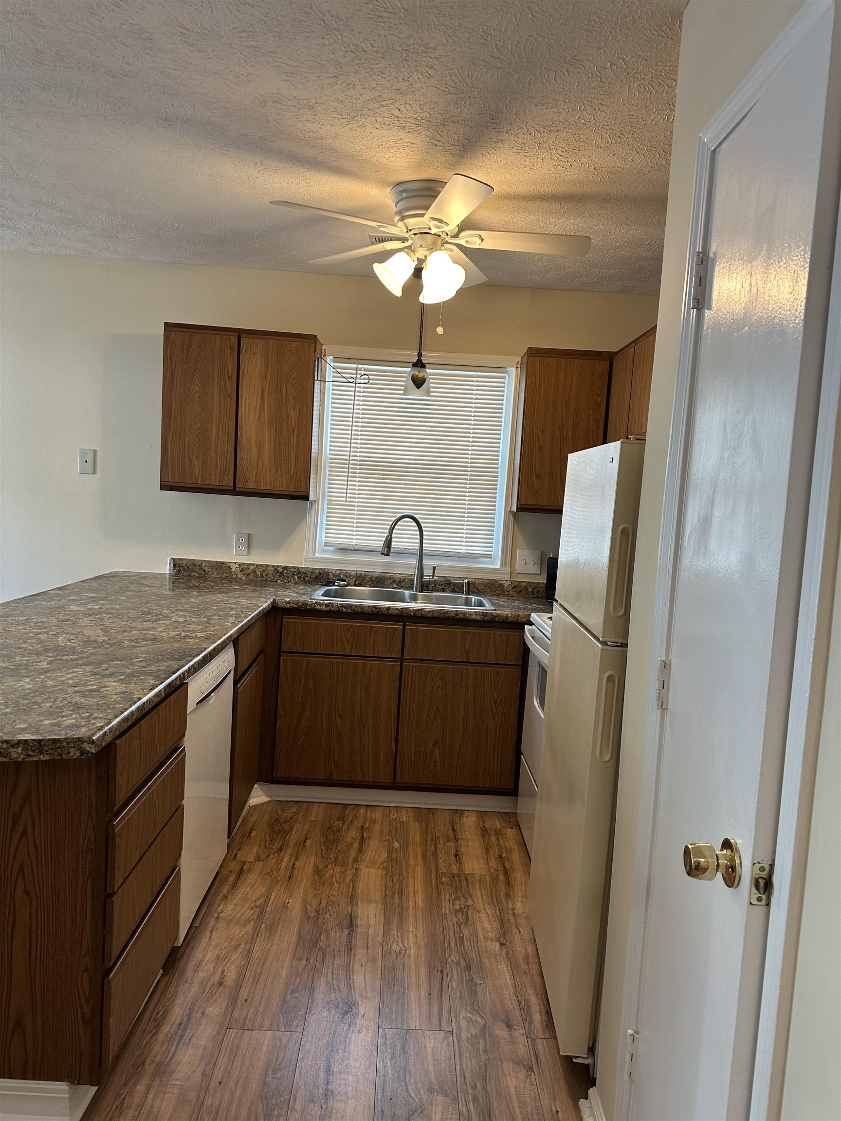 420 Pine Avenue Murrells Inlet, SC 29576 - Photo 11 of 21 Kitchen featuring dark countertops, a peninsula, dark wood finished floors, a textured ceiling, and white appliances