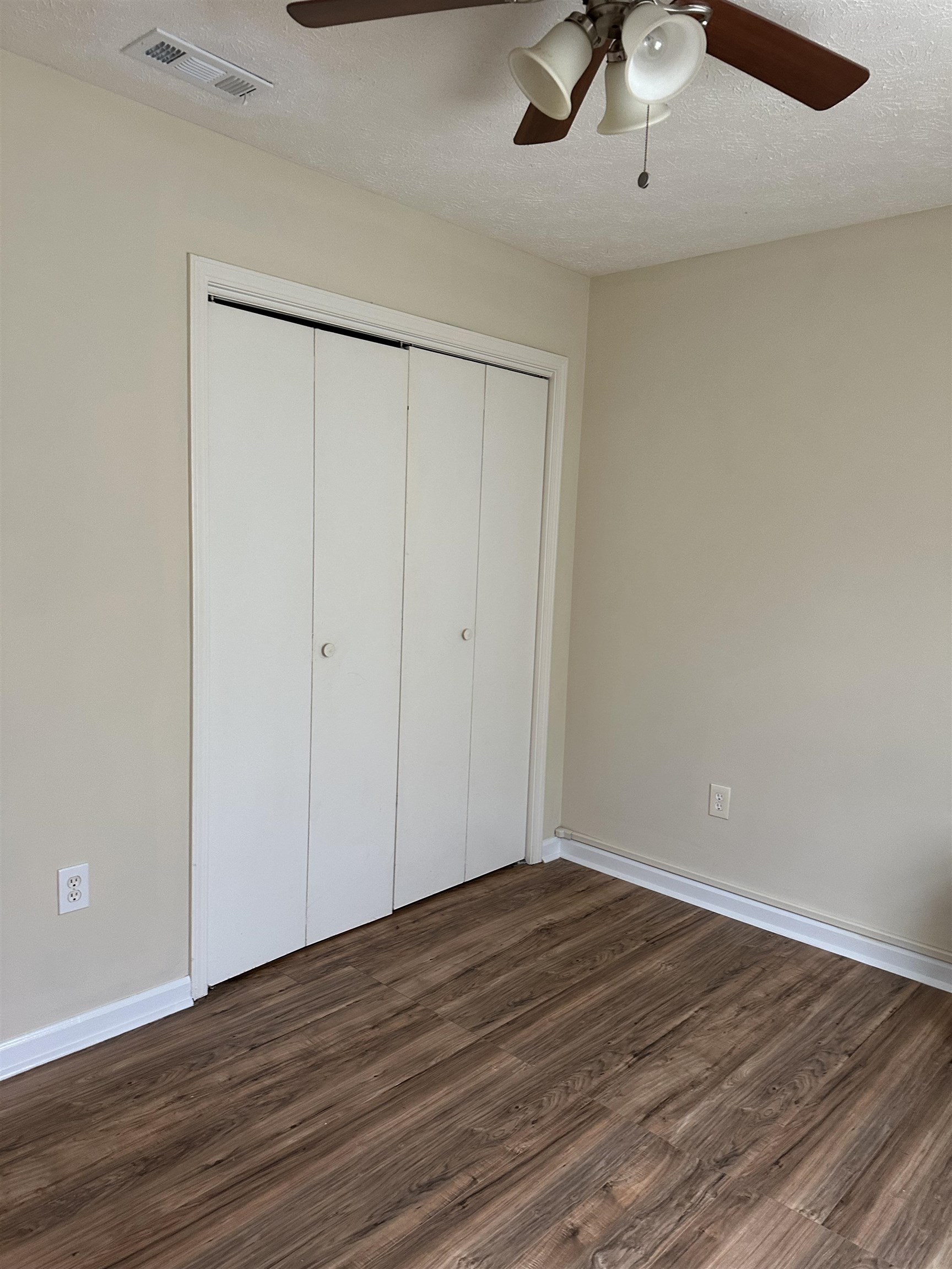 420 Pine Avenue Murrells Inlet, SC 29576 - Photo 13 of 21 Unfurnished bedroom with a textured ceiling, dark wood-style floors, a closet, and a ceiling fan