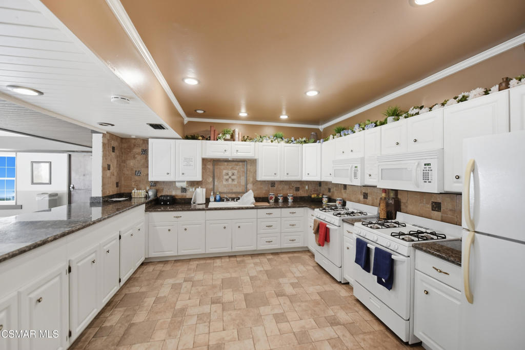 89 Via Gabilan Camarillo, CA 93012 - Photo 26 of 34 a large white kitchen with stainless steel appliances granite countertop a stove and a sink