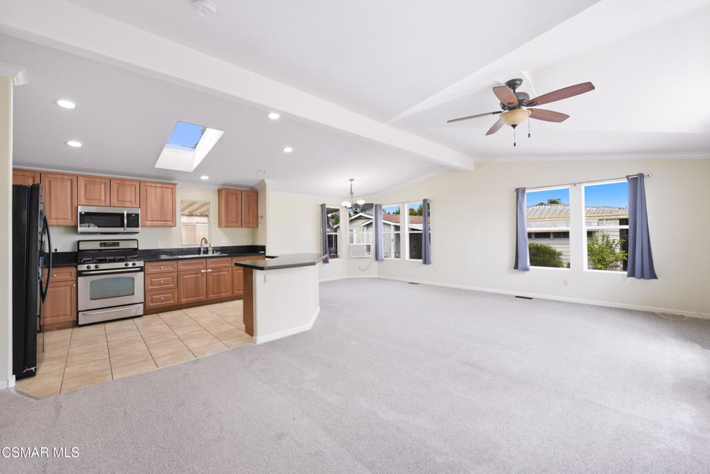 89 Via Gabilan Camarillo, CA 93012 - Photo 4 of 34 a kitchen with stainless steel appliances kitchen island granite countertop a stove a sink a refrigerator with white cabinets and a granite counter top