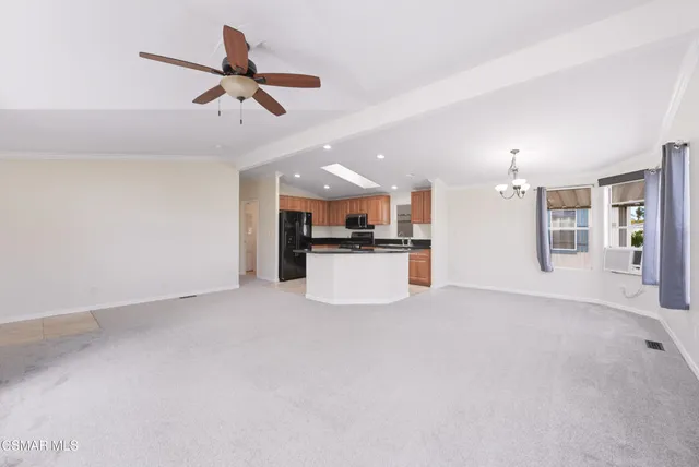 an empty room with a window and a kitchen
