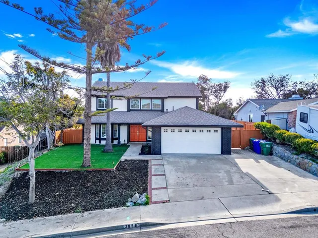 a view of a big house with a yard and potted plants