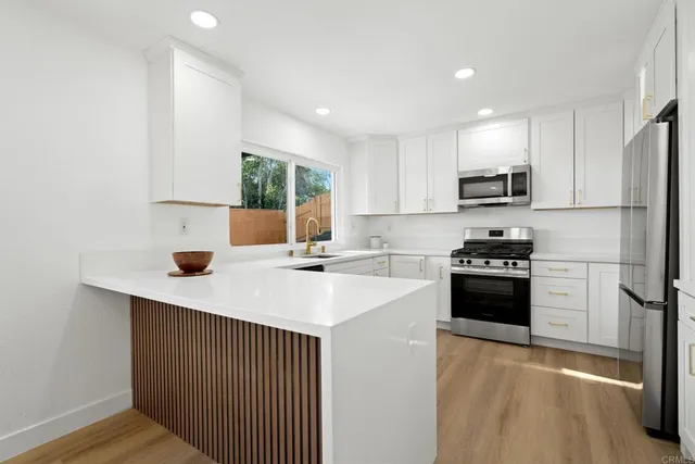 a kitchen with kitchen island a sink appliances and cabinets