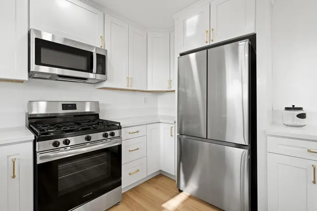 a kitchen with stainless steel appliances a refrigerator stove and microwave