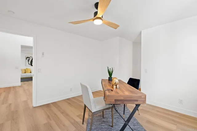 an empty room with wooden floor and ceiling fan
