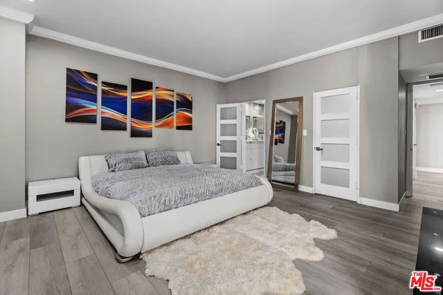 a bedroom with a large bed and a chandelier