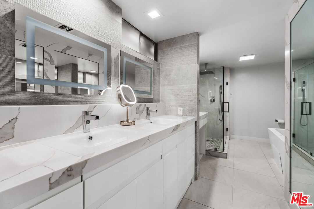 1333 South Beverly Glen Boulevard, Unit 605 Los Angeles, CA 90024 - Photo 16 of 27 a en suite bathroom with double sink and a mirror