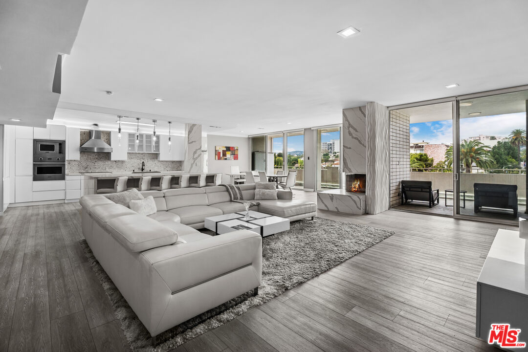 1333 South Beverly Glen Boulevard, Unit 605 Los Angeles, CA 90024 - Photo 3 of 27 a living room with furniture kitchen view and a wooden floor