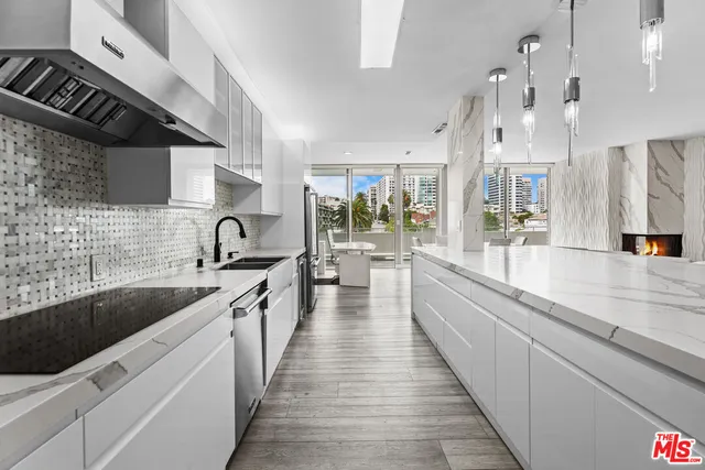 a large kitchen with stainless steel appliances lots of counter space and a sink