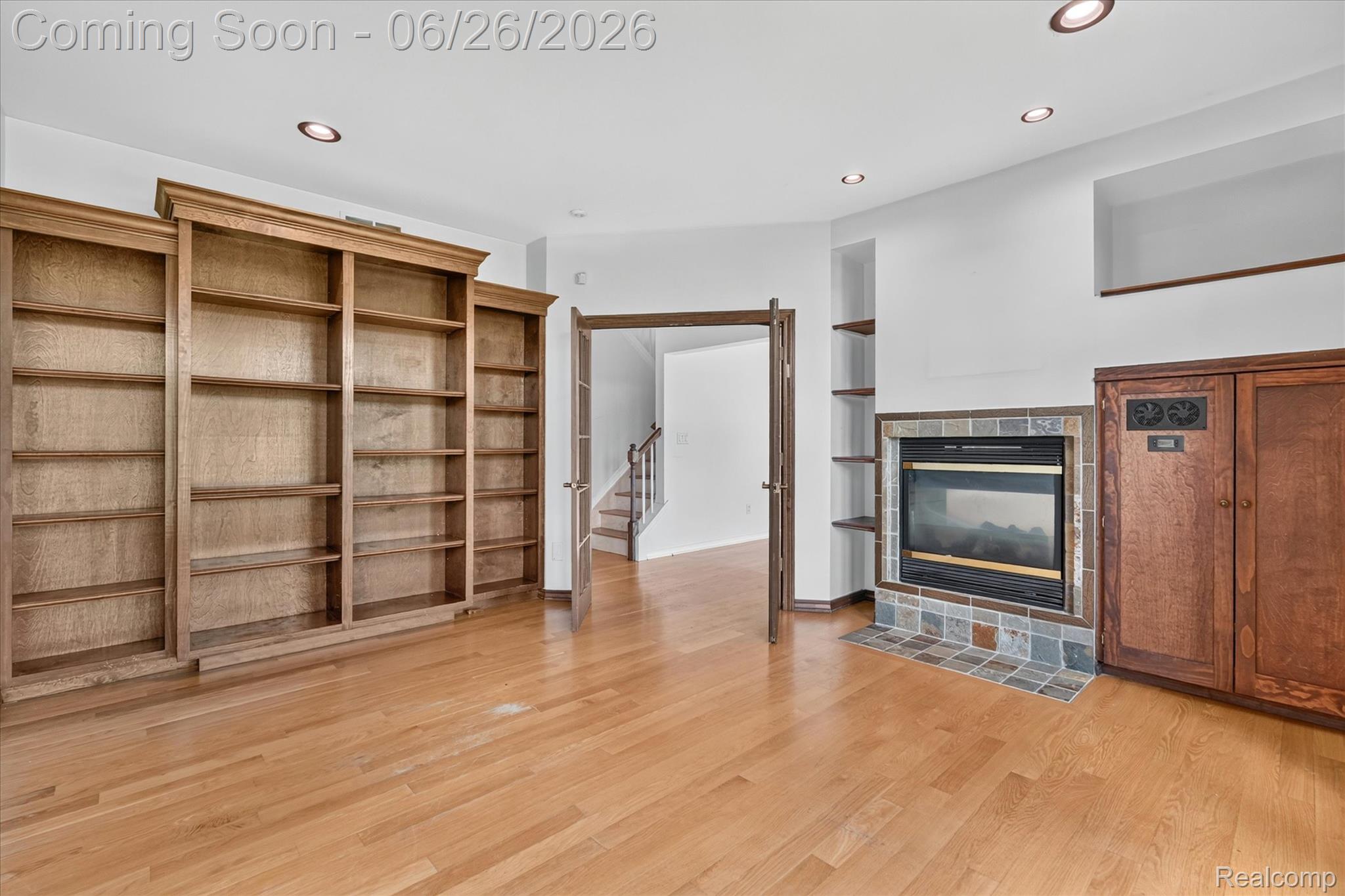 3478 Lexington Road Waterford, MI 48328 - Photo 11 of 52 Spacious room with wood-finish flooring, built-in shelving, a gas fireplace with a tile surround, recessed lighting, and a built-in media cabinet