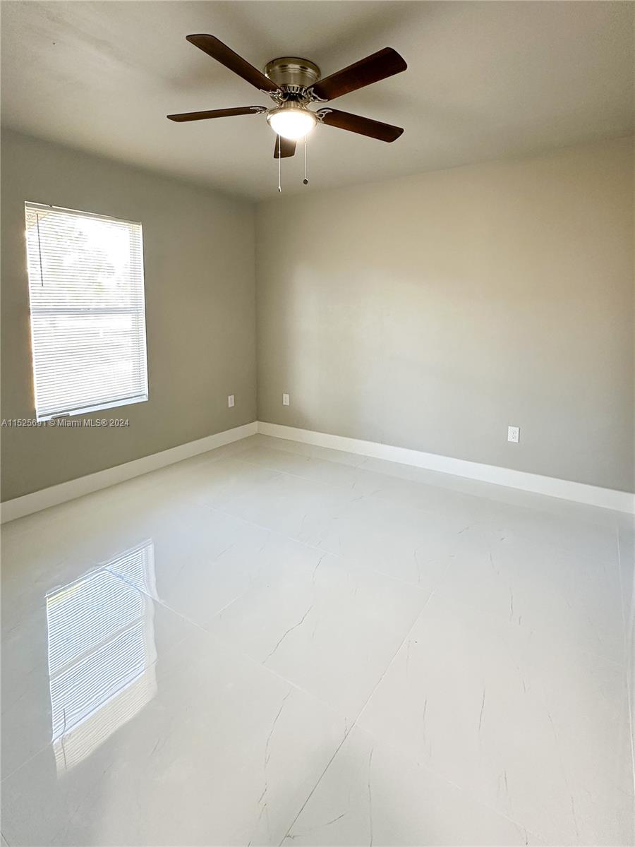 828 Homestead Road South Lehigh Acres, FL 33974 - Photo 13 of 48 an empty room with a window and a fan