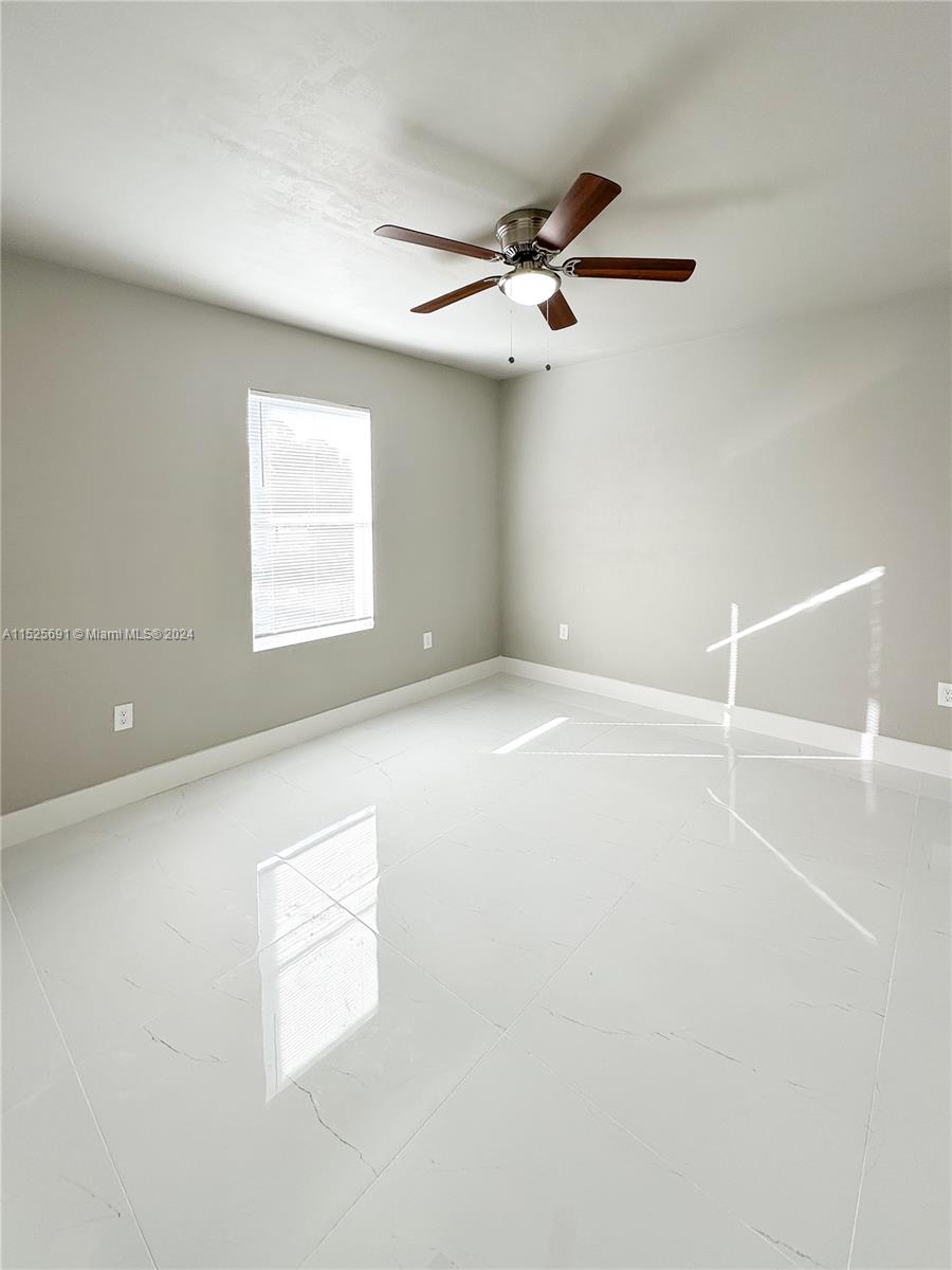 828 Homestead Road South Lehigh Acres, FL 33974 - Photo 23 of 48 an empty room with windows and fan