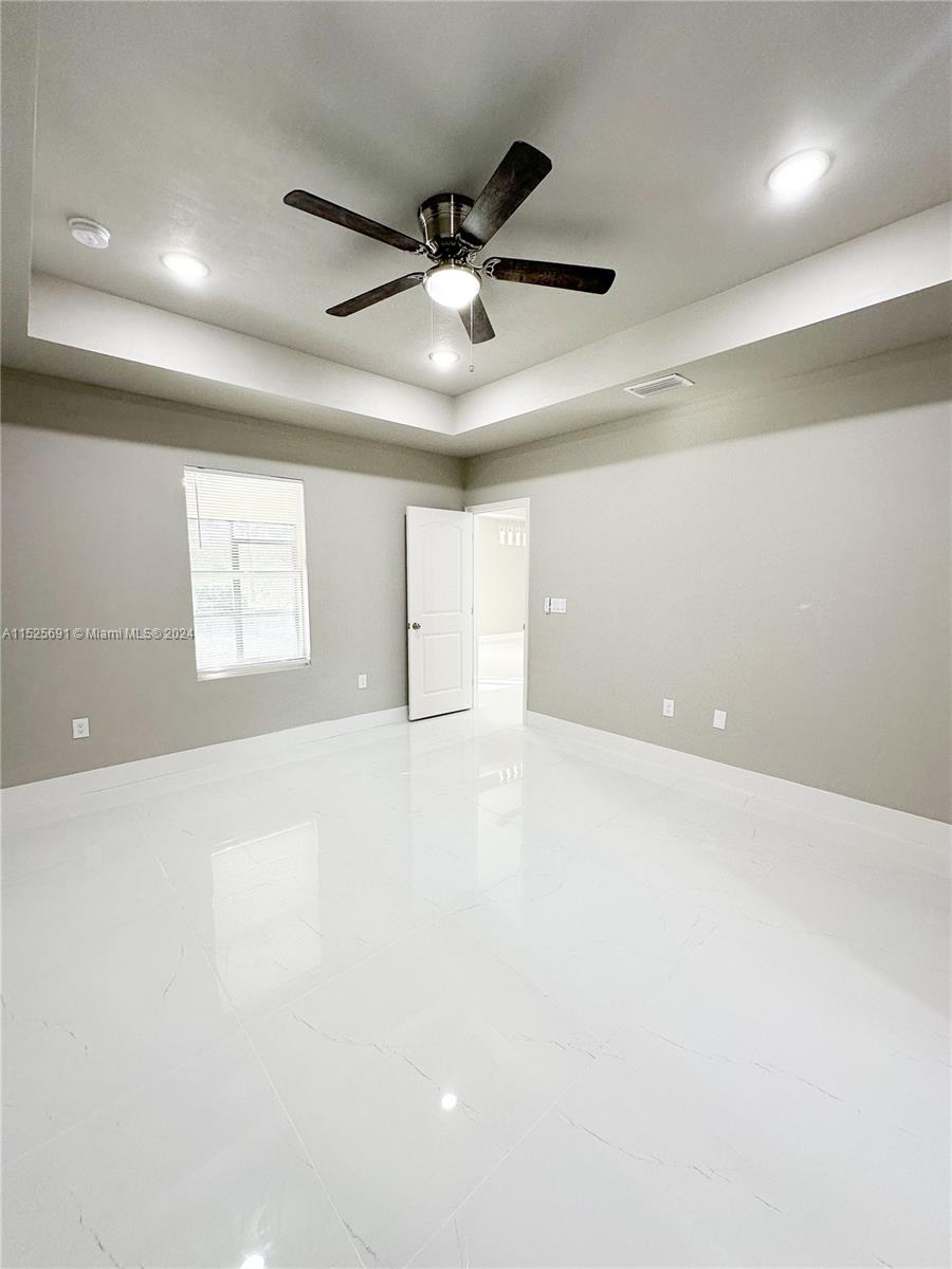 828 Homestead Road South Lehigh Acres, FL 33974 - Photo 27 of 48 an empty room with windows and fan