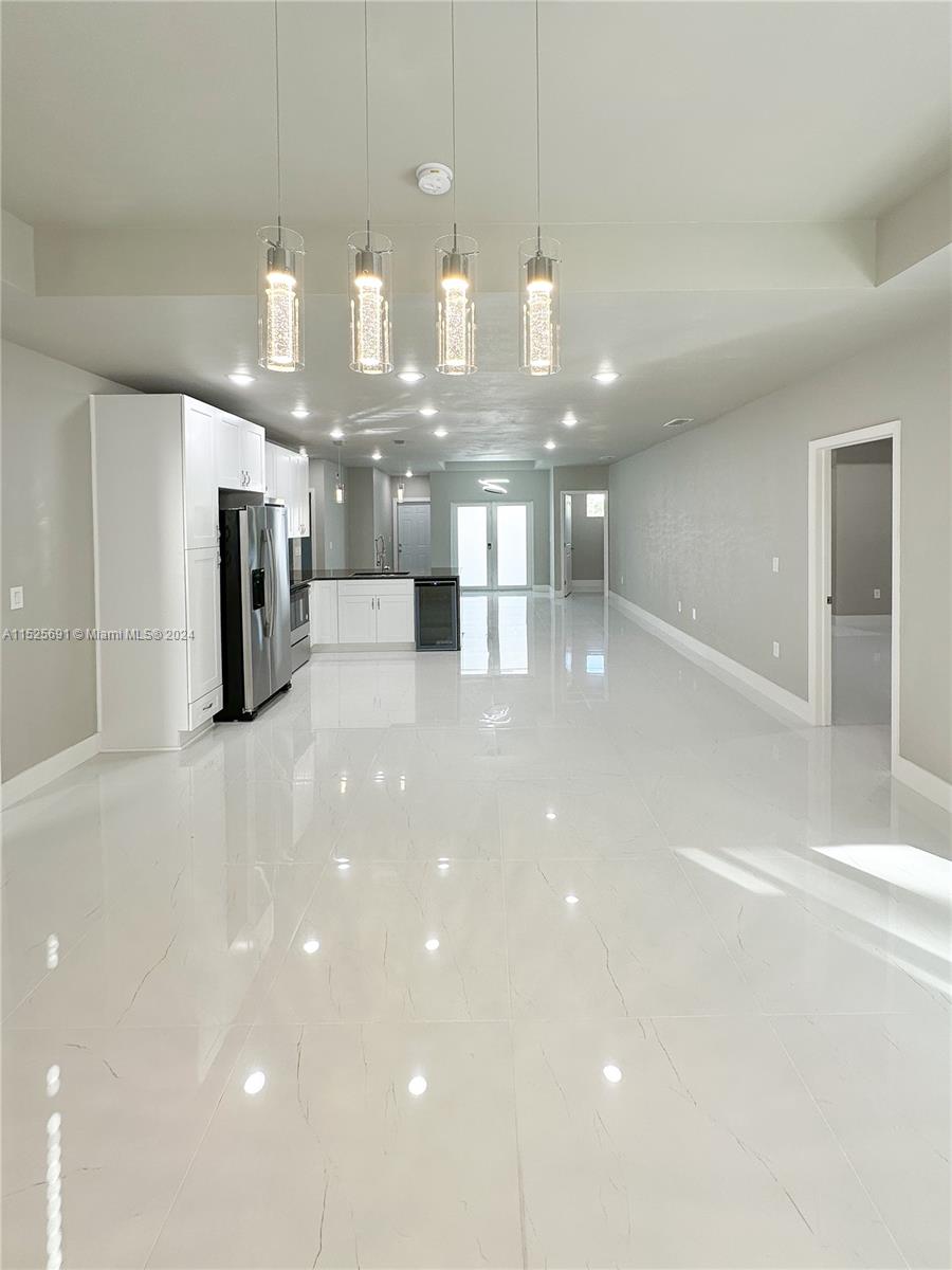 828 Homestead Road South Lehigh Acres, FL 33974 - Photo 3 of 48 a kitchen with a sink and chandelier