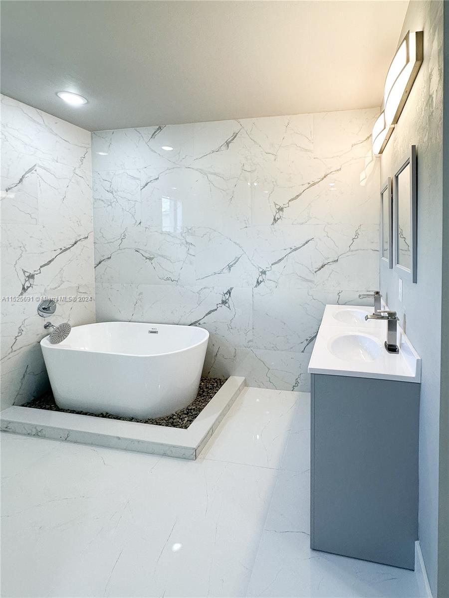 828 Homestead Road South Lehigh Acres, FL 33974 - Photo 31 of 48 a bathroom with a bathtub sink and mirror