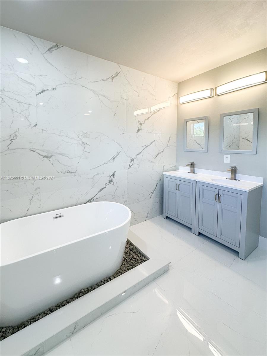 828 Homestead Road South Lehigh Acres, FL 33974 - Photo 34 of 48 a bathroom with a tub sink and mirror