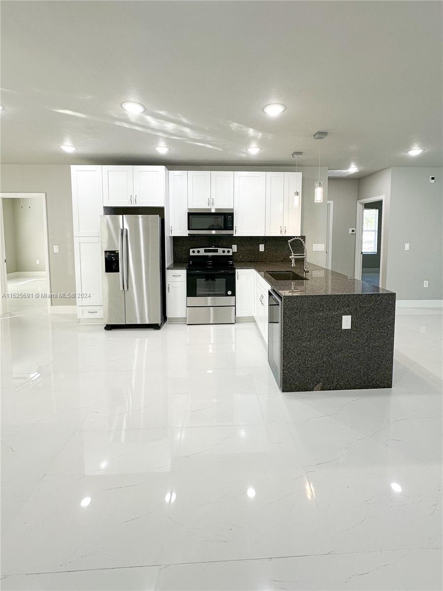 828 Homestead Road South Lehigh Acres, FL 33974 - Photo 4 of 48 a view of kitchen with refrigerator stove and microwave