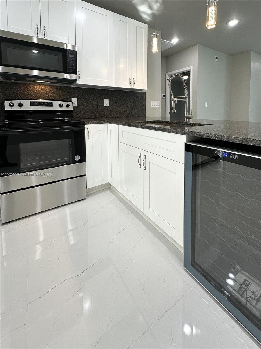 828 Homestead Road South Lehigh Acres, FL 33974 - Photo 10 of 48 a kitchen with granite countertop a stove and a sink