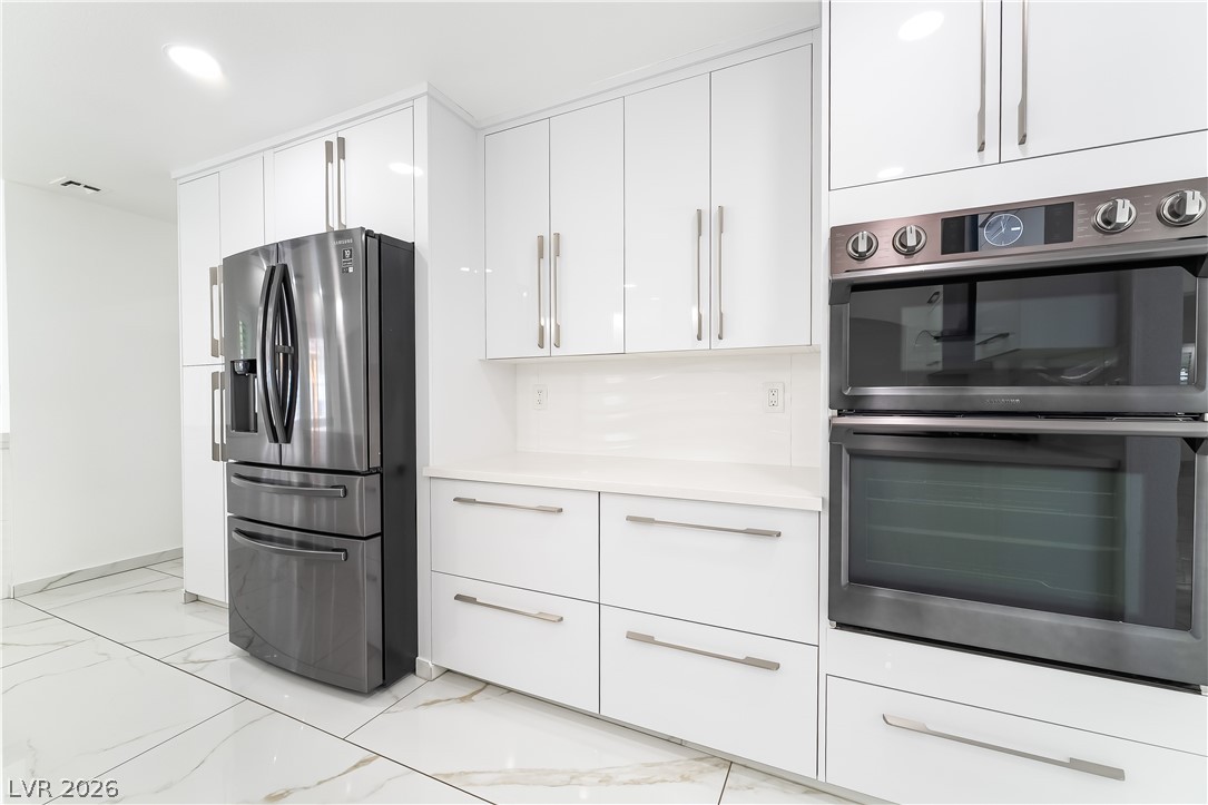 3160 East Viking Road Las Vegas, NV 89121 - Photo 51 of 99 Kitchen featuring stainless steel appliances, white cabinets, light countertops, and recessed lighting