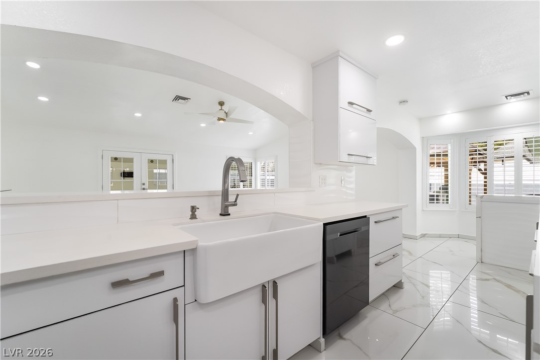 3160 East Viking Road Las Vegas, NV 89121 - Photo 52 of 99 Kitchen with white cabinets, modern cabinets, light marble finish flooring, black dishwasher, and recessed lighting