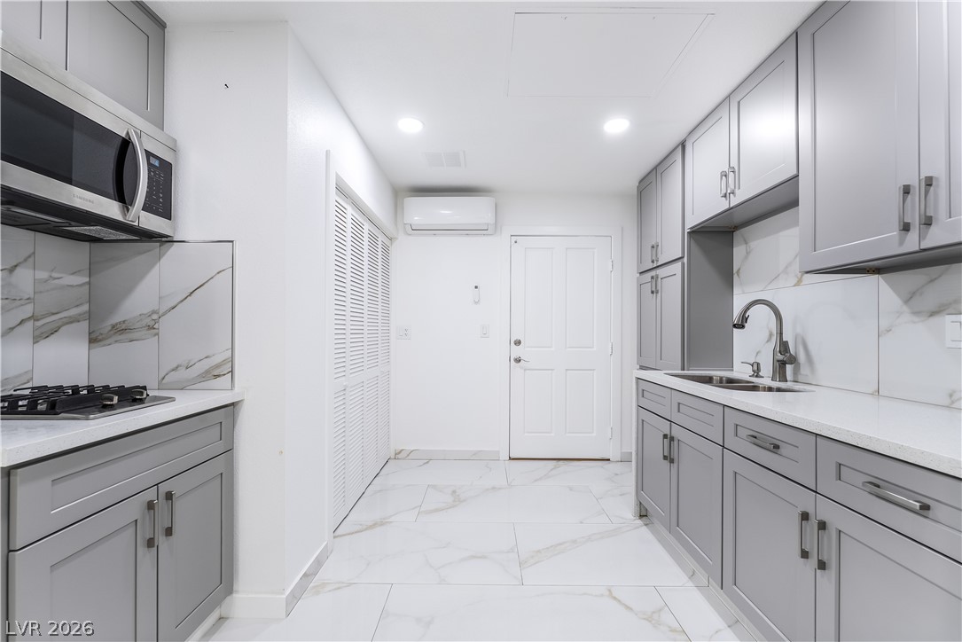 3160 East Viking Road Las Vegas, NV 89121 - Photo 53 of 99 Kitchen featuring gray cabinetry, stainless steel appliances, decorative backsplash, light stone countertops, and recessed lighting