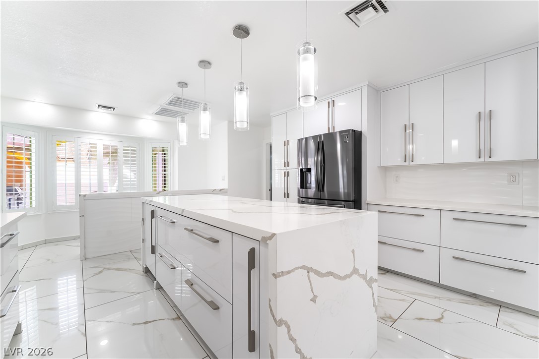 3160 East Viking Road Las Vegas, NV 89121 - Photo 54 of 99 Kitchen with modern cabinets, light marble finish floors, and decorative light fixtures