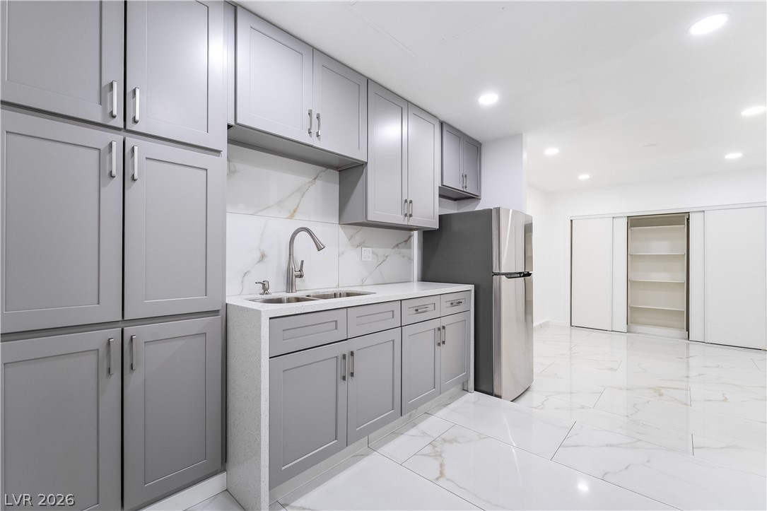 3160 East Viking Road Las Vegas, NV 89121 - Photo 55 of 99 Kitchen featuring gray cabinets, recessed lighting, freestanding refrigerator, decorative backsplash, and light marble finish floors