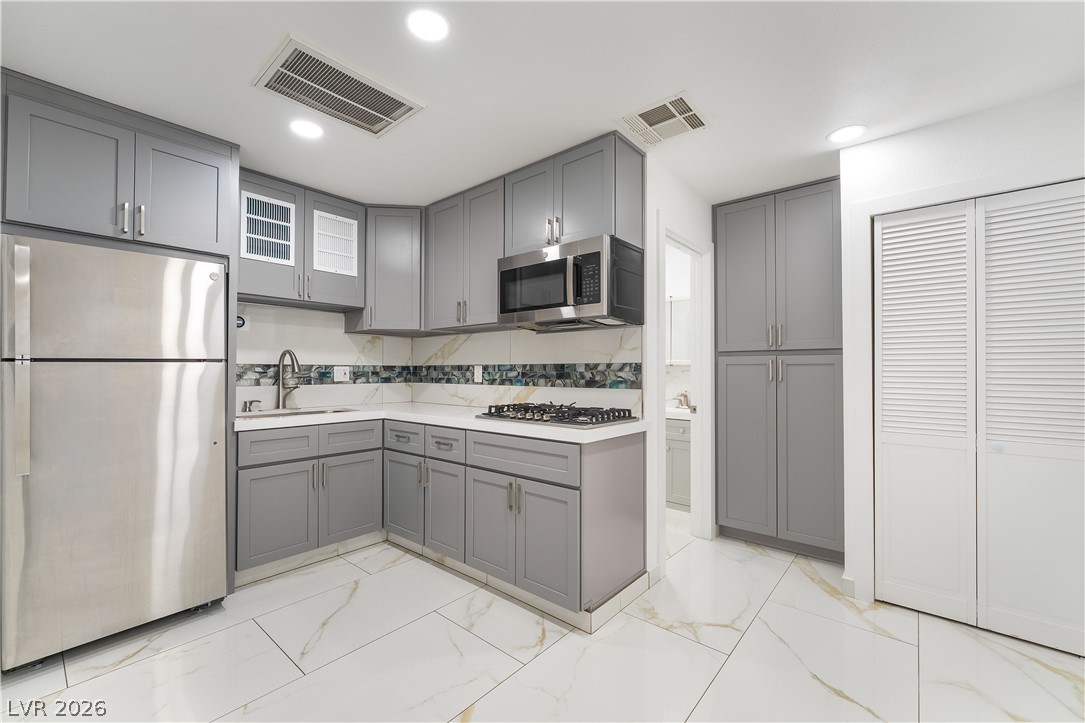 3160 East Viking Road Las Vegas, NV 89121 - Photo 56 of 99 Kitchen with gray cabinets, stainless steel appliances, light marble finish floors, and recessed lighting