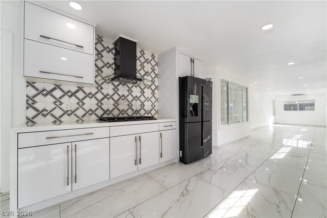 3160 East Viking Road Las Vegas, NV 89121 - Photo 99 of 99 Kitchen with white cabinetry, recessed lighting, black refrigerator with ice dispenser, open floor plan, and light stone counters