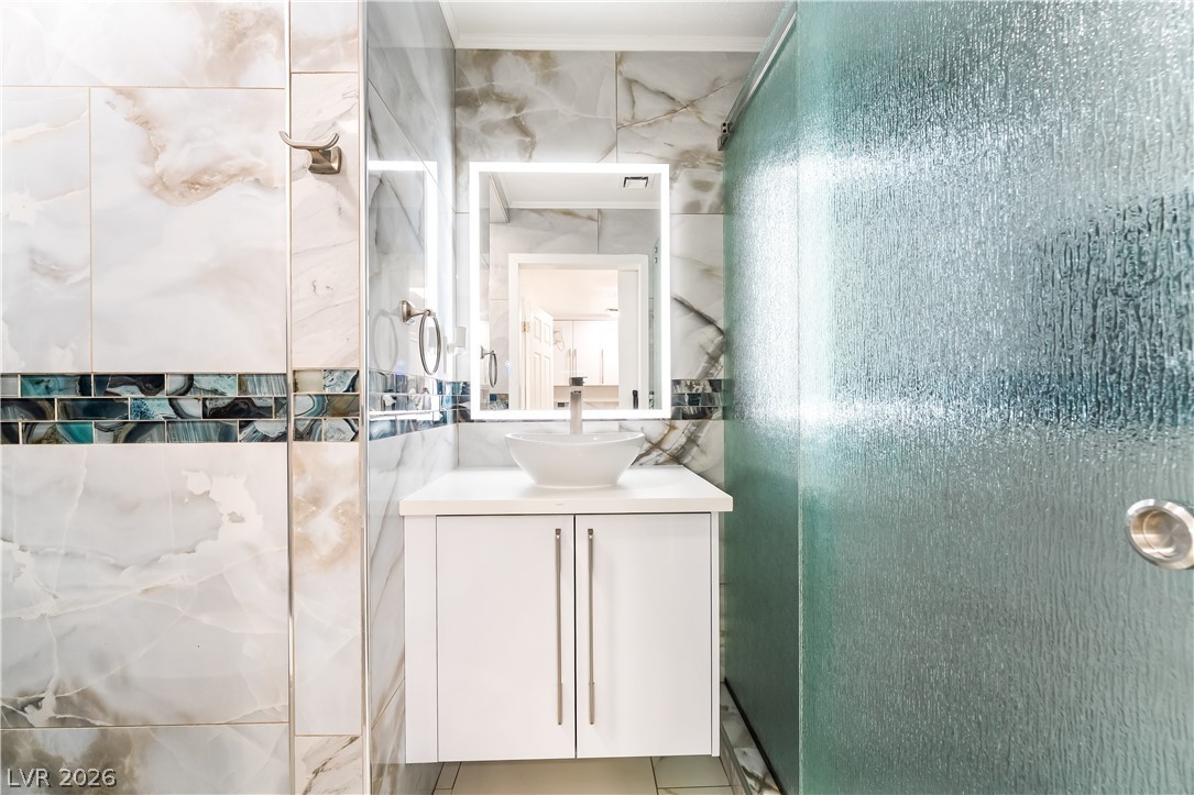 3160 East Viking Road Las Vegas, NV 89121 - Photo 58 of 99 Full bath featuring vanity, a shower stall, and tile walls