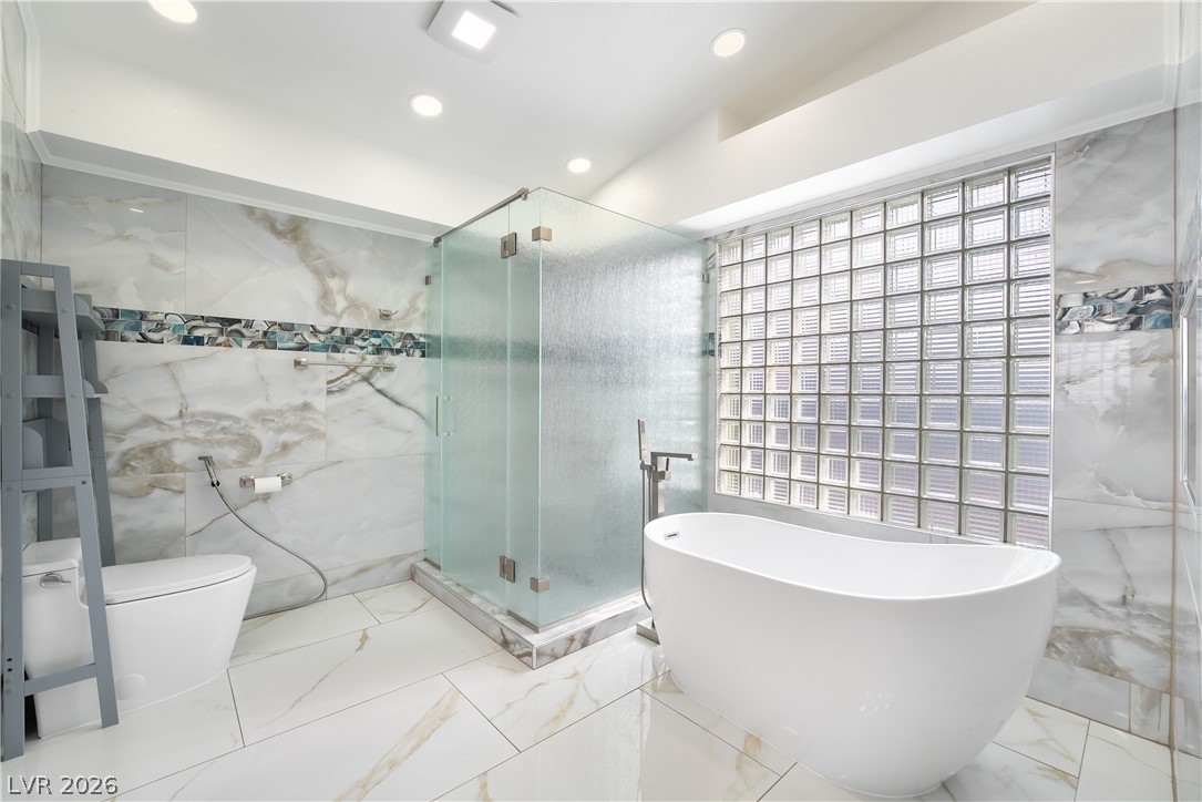 3160 East Viking Road Las Vegas, NV 89121 - Photo 60 of 99 Full bathroom with tile walls, a stall shower, marble tiled floors, a freestanding tub, and recessed lighting