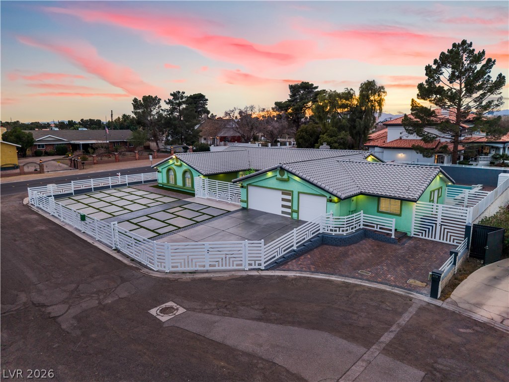 3160 East Viking Road Las Vegas, NV 89121 - Photo 7 of 99 View of front facade featuring a fenced front yard, a tiled roof, asphalt driveway, and a garage
