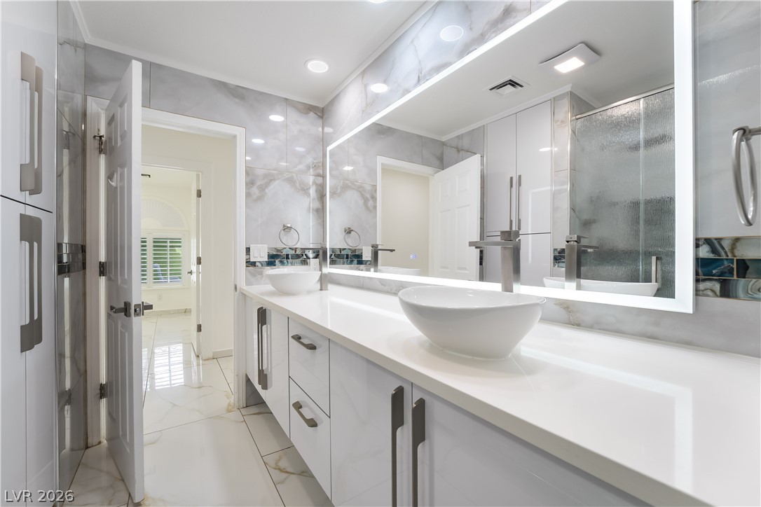 3160 East Viking Road Las Vegas, NV 89121 - Photo 75 of 99 Bathroom featuring double vanity, a stall shower, and light marble finish floors