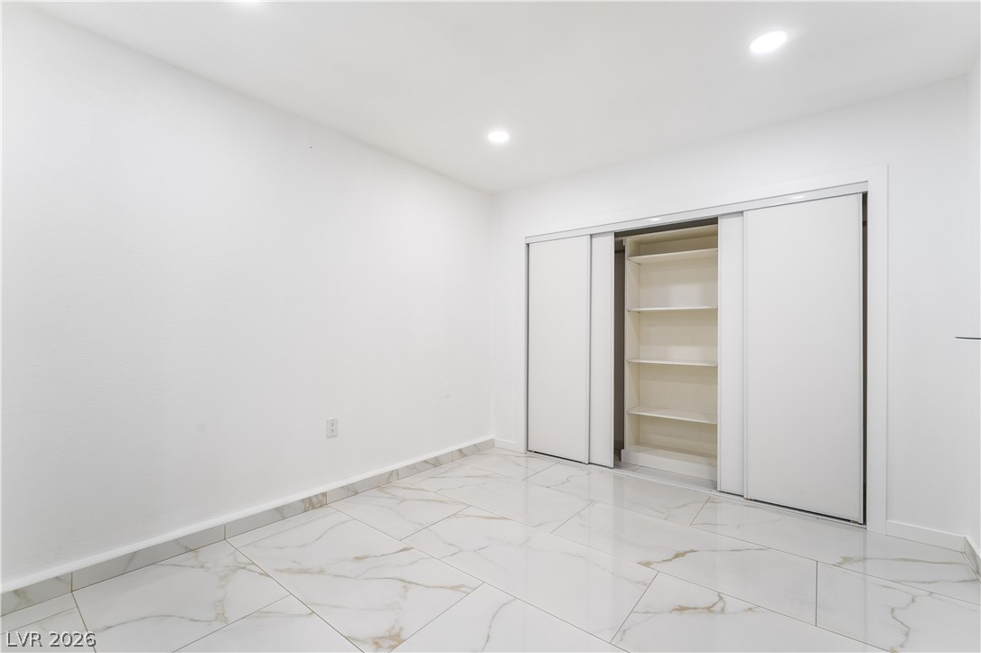 3160 East Viking Road Las Vegas, NV 89121 - Photo 84 of 99 Unfurnished bedroom with light marble finish flooring, recessed lighting, and a closet