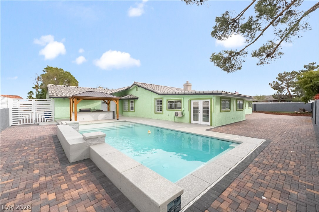 3160 East Viking Road Las Vegas, NV 89121 - Photo 98 of 99 View of swimming pool with french doors, a fenced backyard, a gazebo, a hot tub, and patio surround