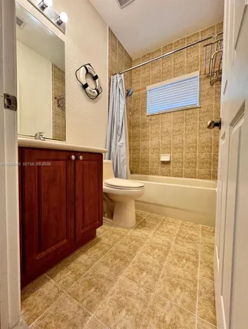 a bathroom with a granite countertop sink a toilet and shower