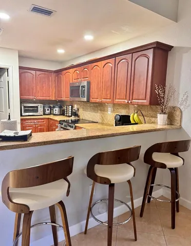 a kitchen with a dining table chairs and a sink