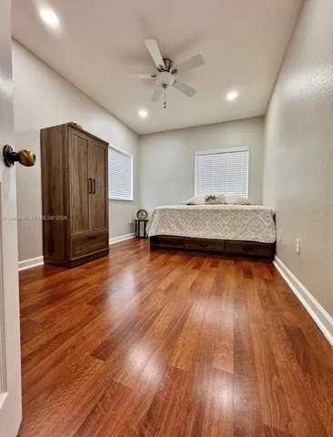 a living room with wooden floors and a ceiling fan