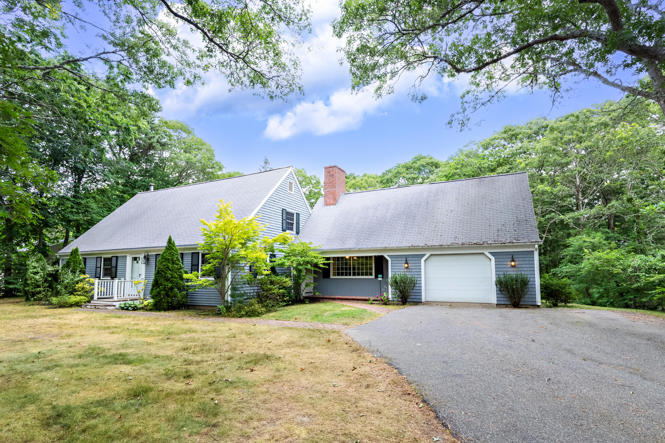 76 Goose Point Road Centerville, MA 02601 - Photo 1 of 34 a front view of a house with a garden