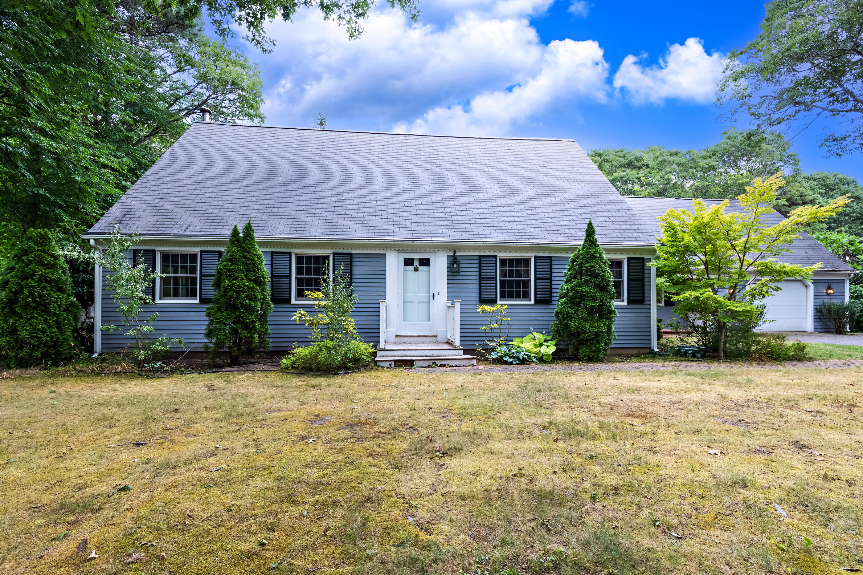 76 Goose Point Road Centerville, MA 02601 - Photo 2 of 34 a front view of a house with a yard and garage
