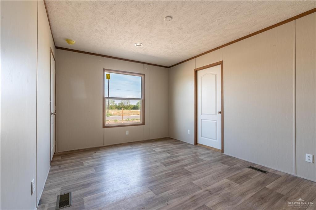 36042 Ranch Park Road San Benito, TX 78586 - Photo 12 of 25 an empty room with wooden floor and windows