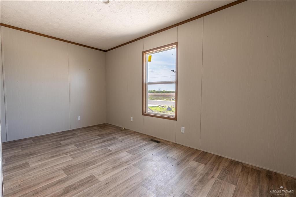 36042 Ranch Park Road San Benito, TX 78586 - Photo 16 of 25 an empty room with wooden floor and windows