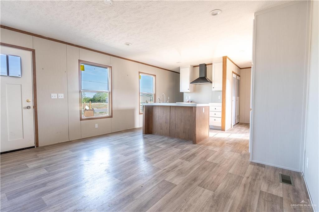 36042 Ranch Park Road San Benito, TX 78586 - Photo 5 of 25 an empty room with wooden floor and windows