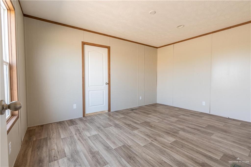 36042 Ranch Park Road San Benito, TX 78586 - Photo 10 of 25 a view of an empty room with wooden floor and a window