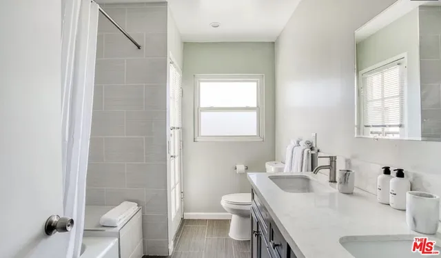 a bathroom with a sink a toilet and a mirror