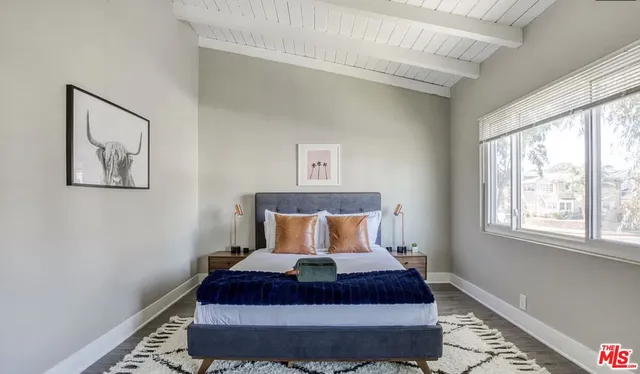 a large bed sitting in a bedroom next to a window