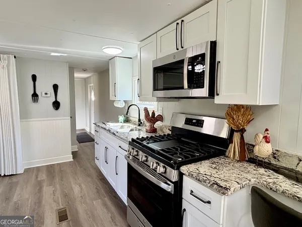 a kitchen with stainless steel appliances granite countertop a stove and a microwave