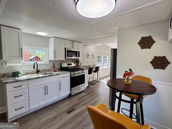 a kitchen with stainless steel appliances kitchen island granite countertop a sink and cabinets